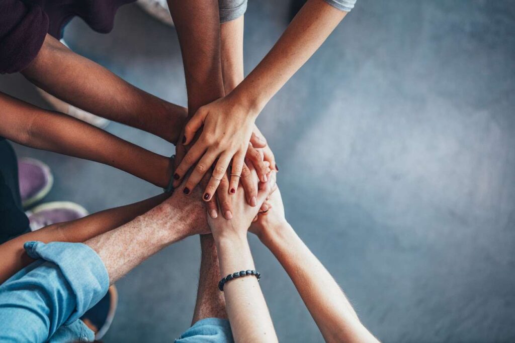 A closeup of young people putting their hands together showing unity