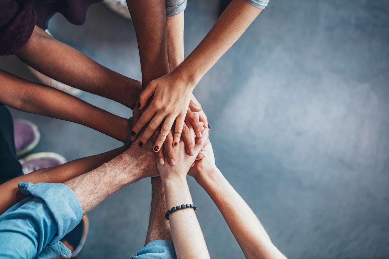 A closeup of young people putting their hands together showing unity