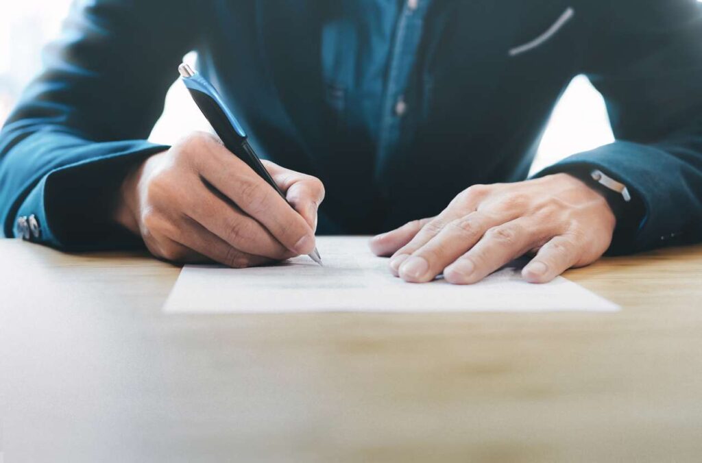 A closeup of a businessman's hands signing a contract